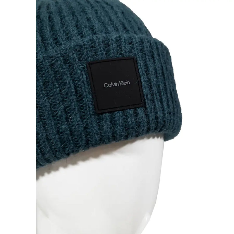 Dark teal ribbed knit beanie featuring a black calvin klein logo patch made from soft knit material