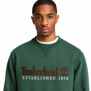 Timberland Grünes Herren-Sweatshirt aus Baumwolle mit dunkelgrünem Stoff, braun gesticktem Logo und weißem Aufdruck „Gründung 1973“.