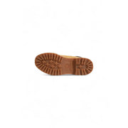 Back view of timberland women’s beige leather ankle boots with a tan textured rubber sole and visible brand logo on heel