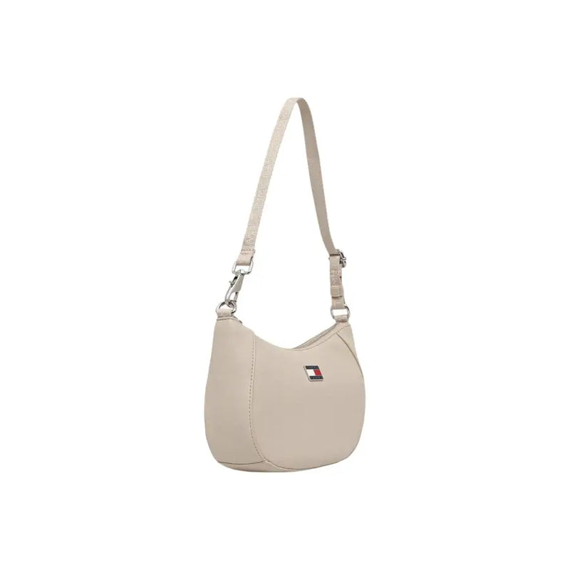Beige tommy hilfiger women’s shoulder bag with sleek curved design zip pocket and subtle logo emblem