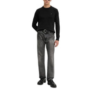Black crew neck sweater with a small logo on the chest, dark wash straight-leg jeans with belt loops and button fly.