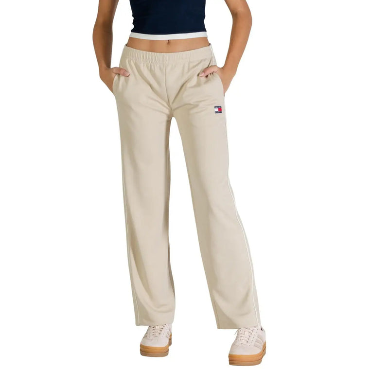 Beige tommy hilfiger sweatpants with white side stripes and small logo patch on the left thigh for women’s spring summer wear
