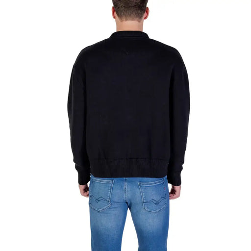 Black zip-up sweater with ribbed cuffs and hem, likely made of cotton or polyester blend.