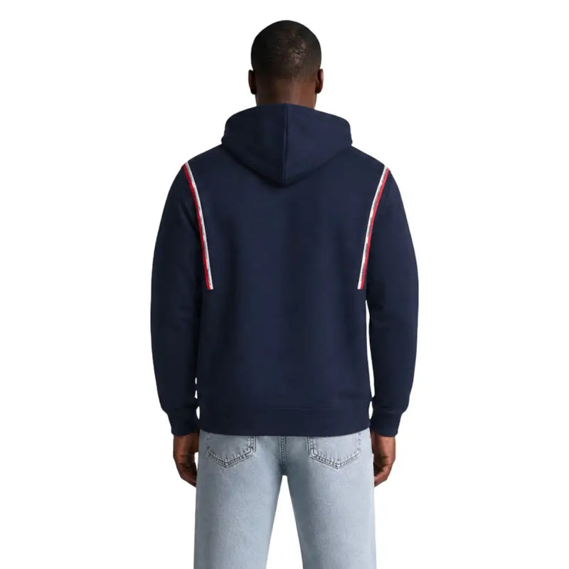 Tommy Hilfiger Jeans Herren-Hoodie aus blauer Bio-Baumwolle mit marineblauem Korpus und rot-weiß gestreiften Ärmeleinsätzen.