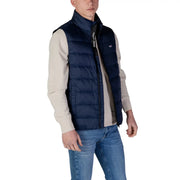 Marineblaue Steppweste mit schwarzem Reißverschluss und Tommy Hilfiger Jeans Markenlogo am Kragen einer ärmellosen Herrenjacke
