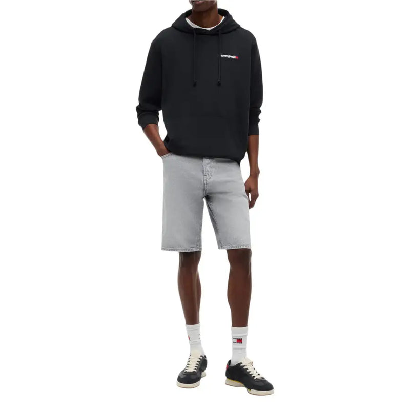 Schwarzer Calvin Klein Hoodie mit kleinem gesticktem Logo auf der Brust, abgebildet mit einem schwarzen Tommy Hilfiger Herren-Sweatshirt aus Bio-Baumwolle.