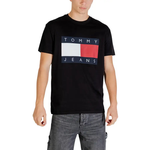 Black tommy hilfiger jeans t-shirt with bold rectangular logo featuring navy blue white and red stripes