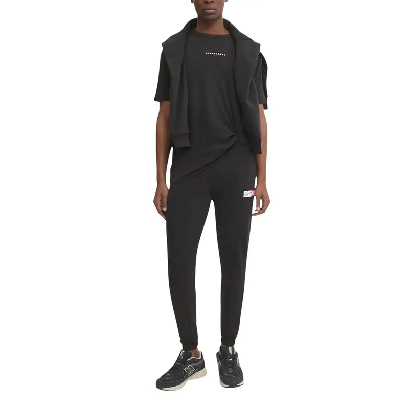 Black tommy hilfiger jeans jogger pants with small white and red logo patch on the left thigh for men