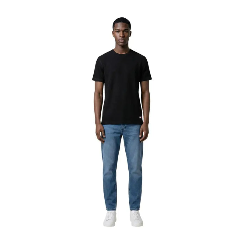 Schwarzes, kurzärmeliges Baumwollshirt mit Rundhalsausschnitt t-shirt mit kleinem rot-weißem Logo unten links von Tommy Hilfiger Jeans