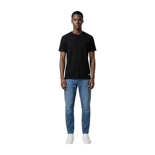 Schwarzes, kurzärmeliges Baumwollshirt mit Rundhalsausschnitt t-shirt mit kleinem rot-weißem Logo unten links von Tommy Hilfiger Jeans