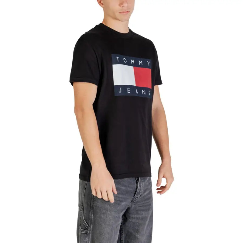 Schwarz Tommy Hilfiger Jeans t-shirt mit einem markanten rechteckigen Logo mit weißen und roten Streifen, die von einem marineblauen Text umrandet sind