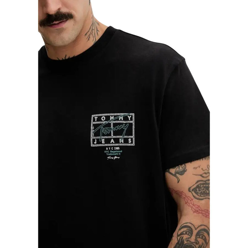 Schwarze Tommy Hilfiger Jeans für Herren t-shirt mit weißem rechteckigem Logo, das den Markennamen und die Unterschrift auf der Vorderseite zeigt