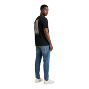 Rückseite eines schwarzen, kurzärmeligen Baumwollhemdes t-shirt von Tommy Hilfiger Jeans mit einer grauen rechteckigen Grafik und Text