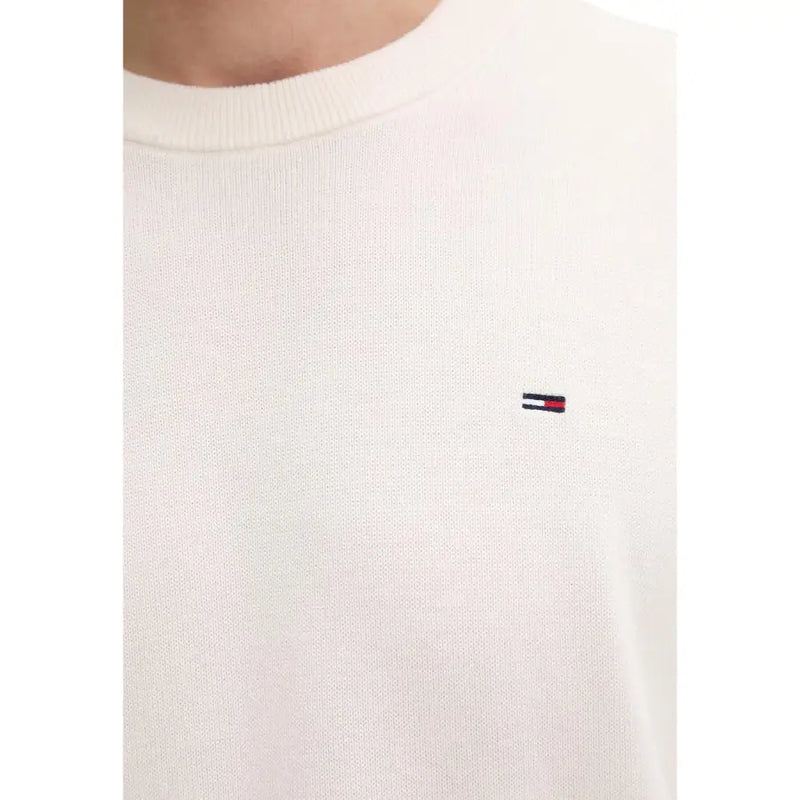 Cremefarbener Strickpullover mit Rundhalsausschnitt aus Bio-Baumwolle mit gesticktem Tommy Hilfiger Logo auf der linken Brust.