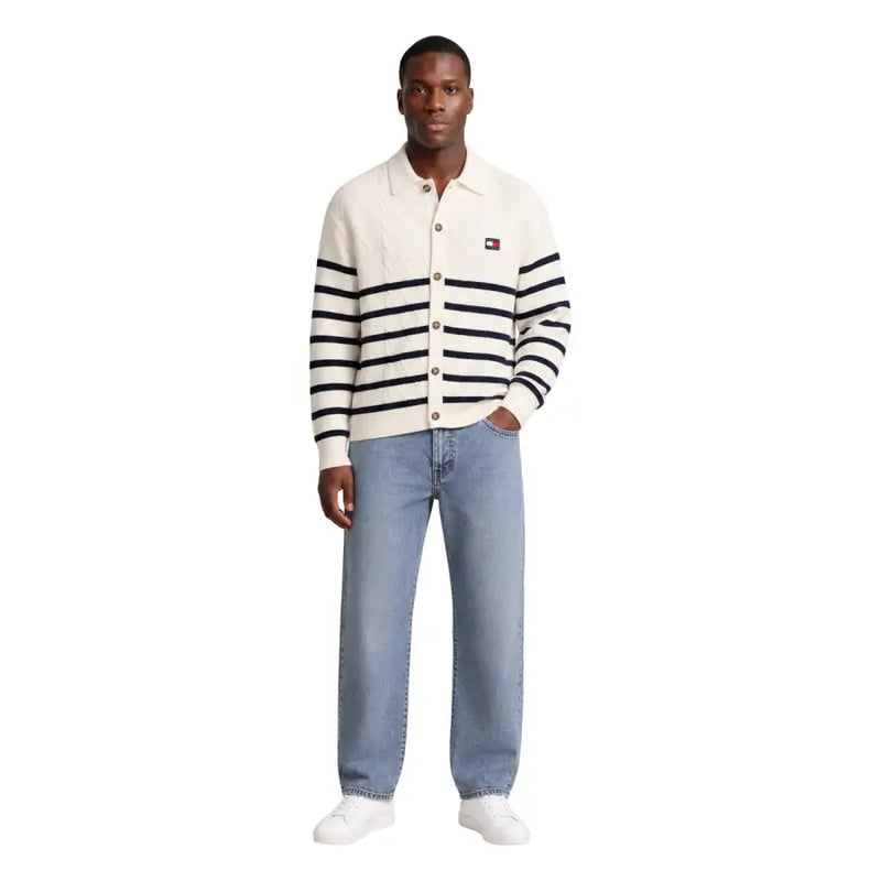 Cremefarbene Strickjacke mit schwarzen Streifen und Tommy Hilfiger Logo-Patch, die perfekt zum weißen Herren-Sweatshirt aus Bio-Baumwolle passt.