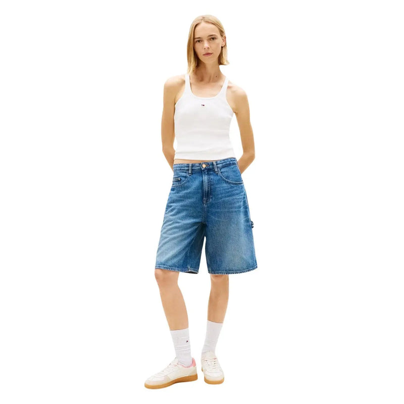 Blaue Jeansshorts mit fünf Taschen und dezenter Waschung, kombiniert mit einem weißen Baumwoll-Tanktop von Tommy Hilfiger. top Riemen