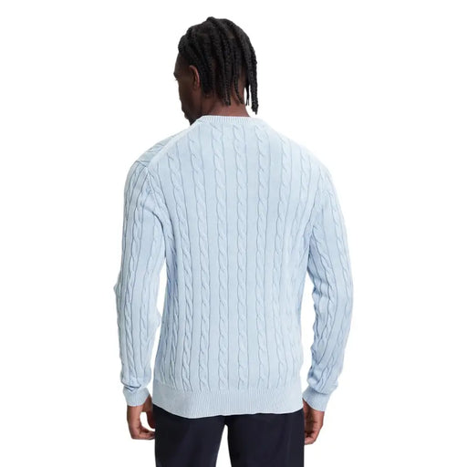 Light blue cable knit sweater with navy pants and dreadlocks.