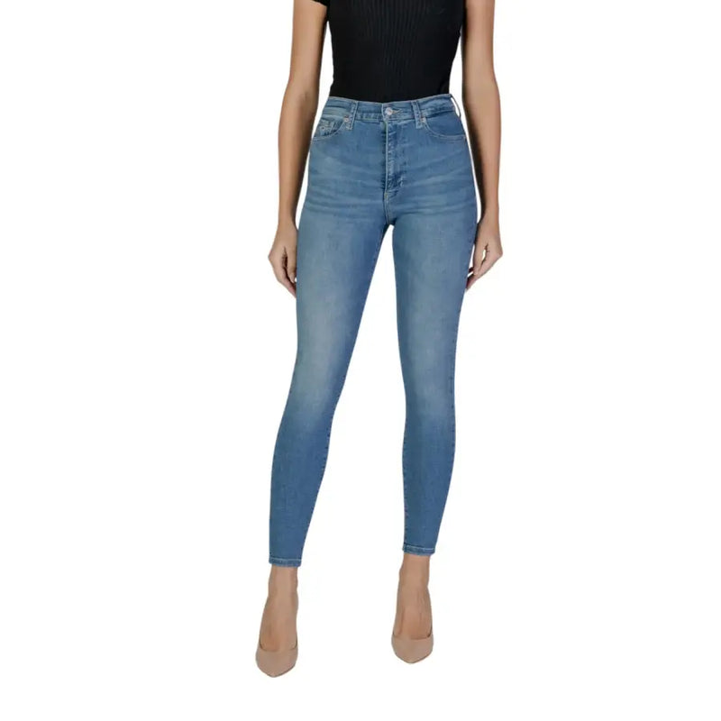 Hellblaue Skinny-Jeans an einer Frau, kombiniert mit einem schwarzen top und nudefarbene High Heels von Tommy Hilfiger