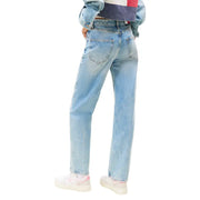 Light wash Tommy Hilfiger women jeans with worn out effect paired with pink-accented sneakers