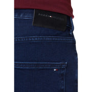 Dark blue denim jeans made from organic cotton featuring a black tommy hilfiger waistband label and signature logo