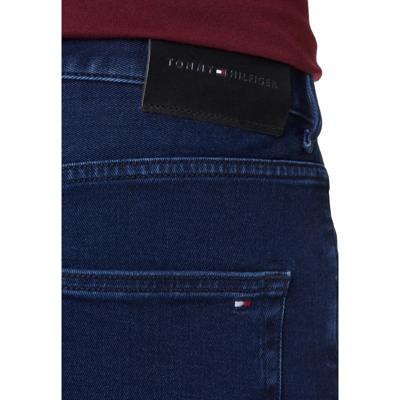 Dark blue denim jeans made from organic cotton featuring a black tommy hilfiger waistband label and signature logo