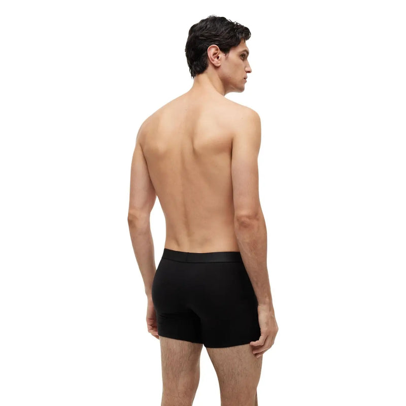 Schwarze Calvin Klein Boxershorts mit glattem, figurbetontem Design, von hinten gesehen, aus schwarzer Bio-Baumwolle von Tommy Hilfiger.