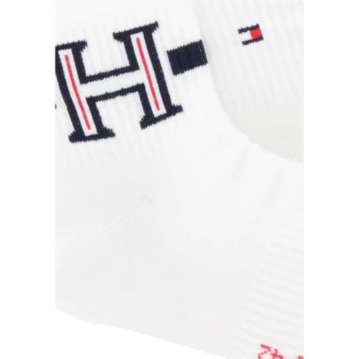 Weiße Stricksocke mit auffälligem schwarzem H-Logo, roten Streifen und Tommy-Hilfiger-Flaggenemblem, passend zu Herrenboxershorts.