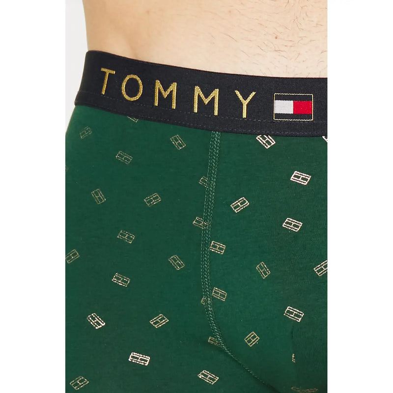 Dunkelgrüne Tommy Hilfiger Herren-Boxershorts aus Baumwolle mit goldenem Logomuster und schwarzem Bund mit goldenem Markennamen