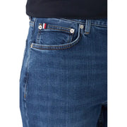Dunkelblaue, schmal geschnittene Jeans aus Bio-Baumwolle mit silbernen Knöpfen und einem Flaggenaufnäher auf der Gesäßtasche.
