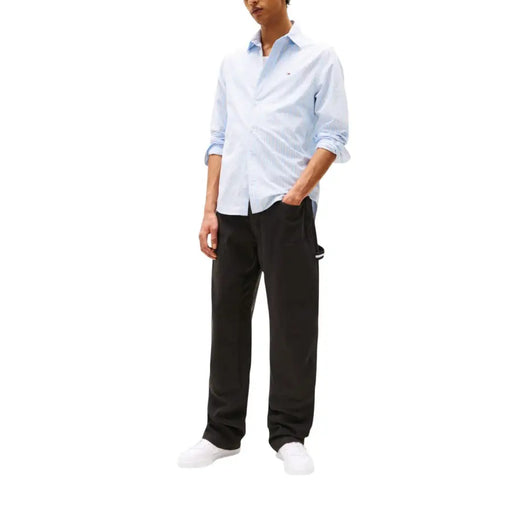 Men’s light blue long-sleeve button-down shirt paired with Tommy Hilfiger black jeans