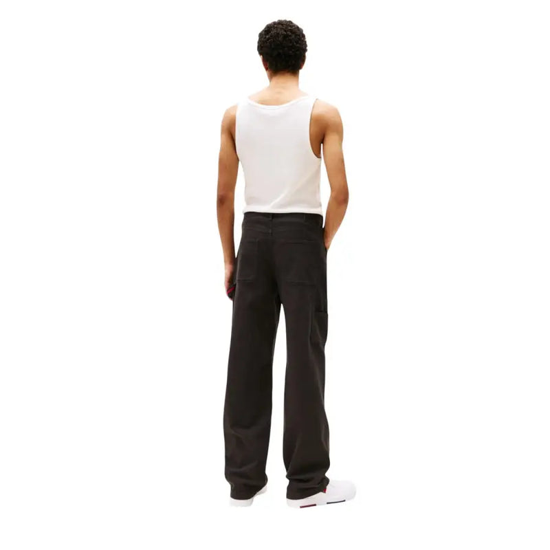 Men’s white tank top and black wide-leg trousers from Tommy Hilfiger Organic Cotton collection