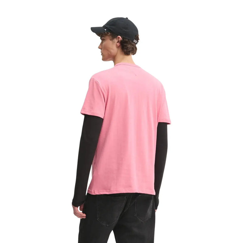 Tommy Hilfiger Herren-T-Shirt aus rosa Bio-Baumwolle, normale Passform, getragen über einem schwarzen Langarmshirt