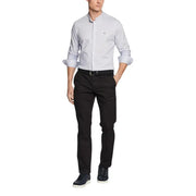 Hellgraues Tommy Hilfiger Herrenhemd mit hochgekrempelten Ärmeln und dezentem Logo auf der Brust, kombiniert mit einer Hose.