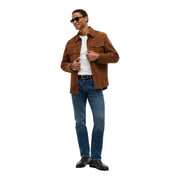 Tommy Hilfiger Slim-Fit-Jeans für Herren in Blau, getragen von einem Model mit brauner Wildlederjacke, Brusttaschen, Kragen sichtbar, Vorderansicht