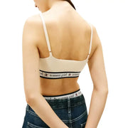 Beige ribbed tommy girl bra with thin straps and black elastic band featuring tommy hilfiger logo under white sleeveless v neck knit top for women