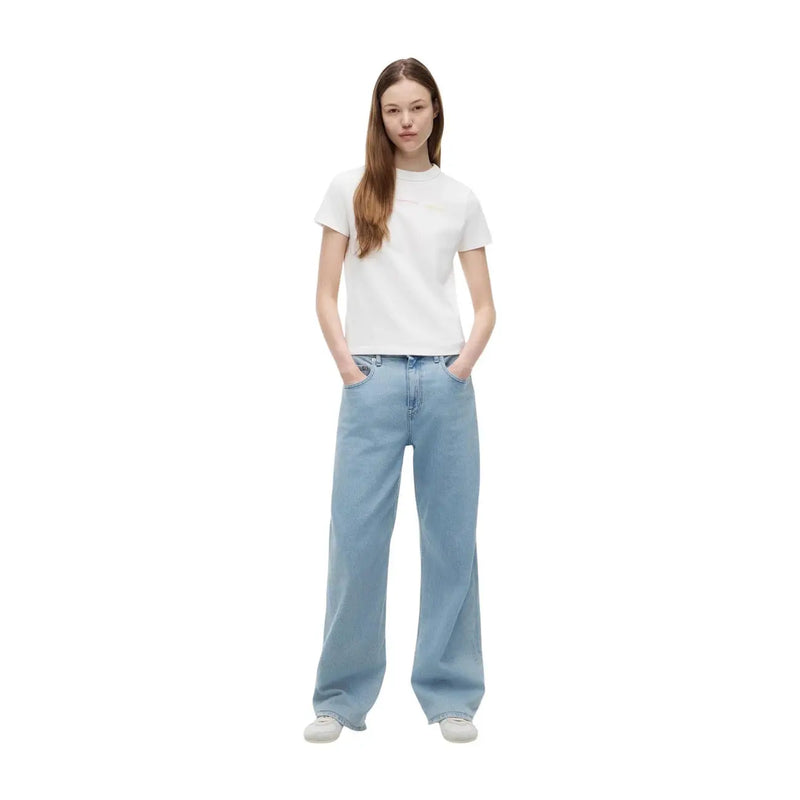 Hellblaue, weit geschnittene Jeans, kombiniert mit einem weißen, kurzen T-Shirt aus Bio-Baumwolle von Tommy Hilfiger für Damen (Vorderansicht).