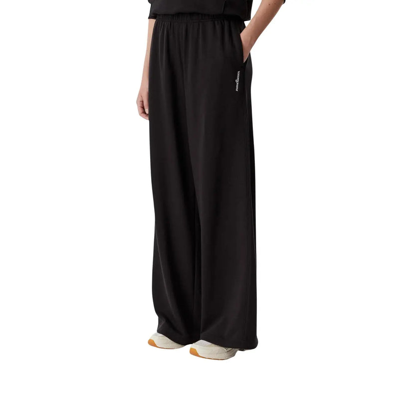 Tommy Hilfiger Schwarze Damen-Jogginghose mit weitem Bein aus weich fließendem Baumwollstoff und dezentem seitlichem Logo.