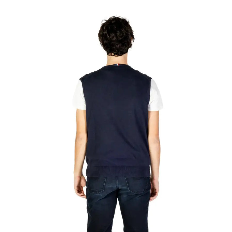 Navy blue sleeveless sweater vest with white trim and ribbed edges, likely made of cotton or polyester blend.