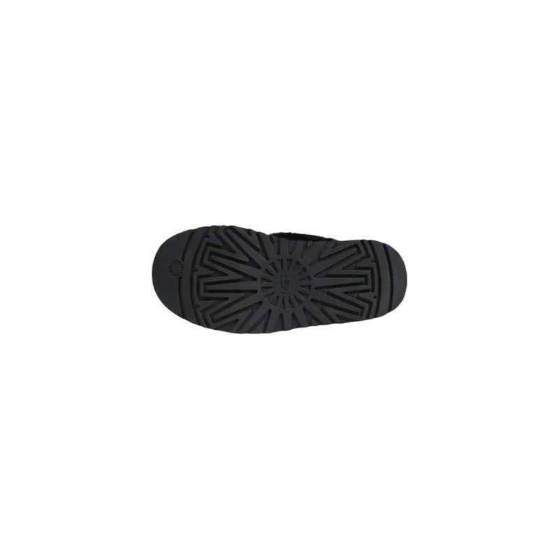 Back side of ugg women black suede leather slippers showing black rubber sole with starburst tread pattern and logo embossed near heel