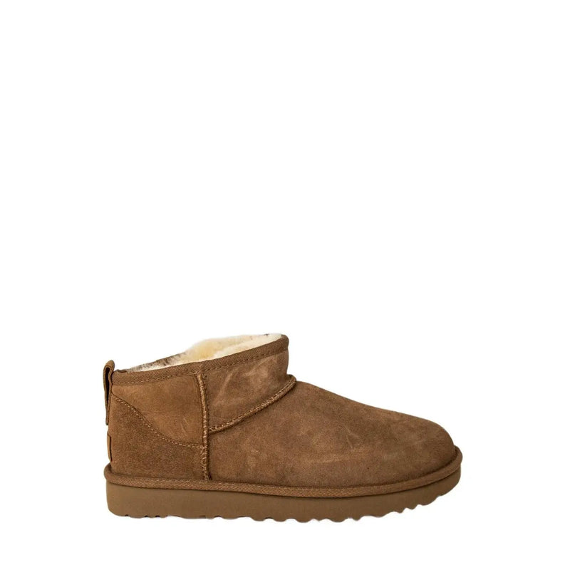 Tan suede ugg women leather boot with plush white shearling lining and rubber sole shown from the back side