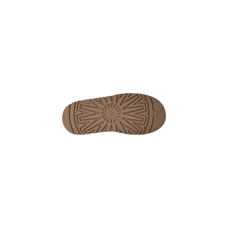 Back side of ugg women suede platform slippers in beige showing tan rubber sole with geometric tread pattern and ugg logo embossed near heel