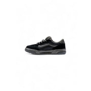 Black and white low-top sneakers with a glossy patent leather upper, vans old skool model.