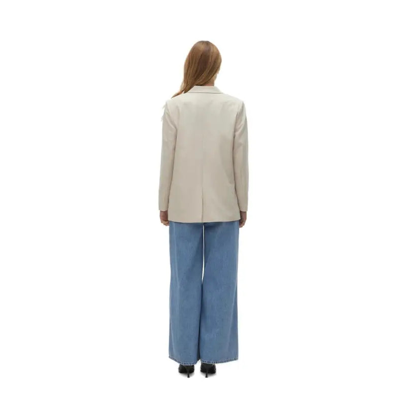 Vero moda women’s beige blazer with button and front pockets featuring tailored fit and subtle texture paired with blue wide-leg denim trousers