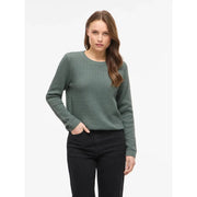 Schwarzes, langes Baumwollstrickoberteil von Vila mit Rundhalsausschnitt, kombiniert mit einem olivgrünen, strukturierten Strickpullover mit Rippbündchen.