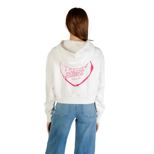 White cropped hoodie with pink heart graphic and TOMMY JEANS text on the back