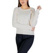 Cream-colored knit sweater with wooden shoulder buttons, white long sleeve top
