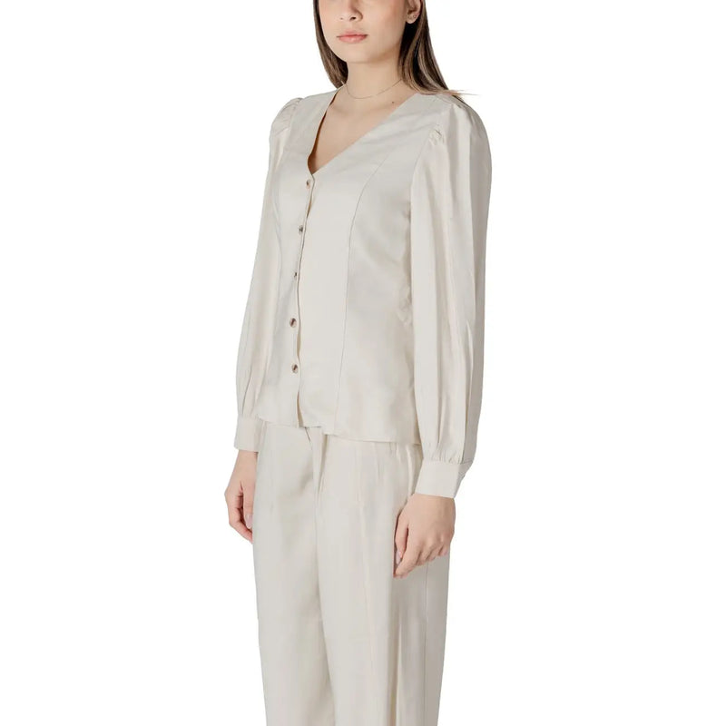 A soft cream-colored viscose blouse for women featuring long sleeves, v-neck, button-up front, and subtle pleats