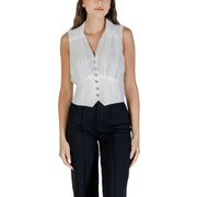 White sleeveless V-neck zip top with pointed hem paired with black trousers for fall winter fashion