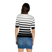 Frau in weiß gestreifter, kurzärmeliger Strickjacke mit Knöpfen, schwarz-weiße horizontale Streifen