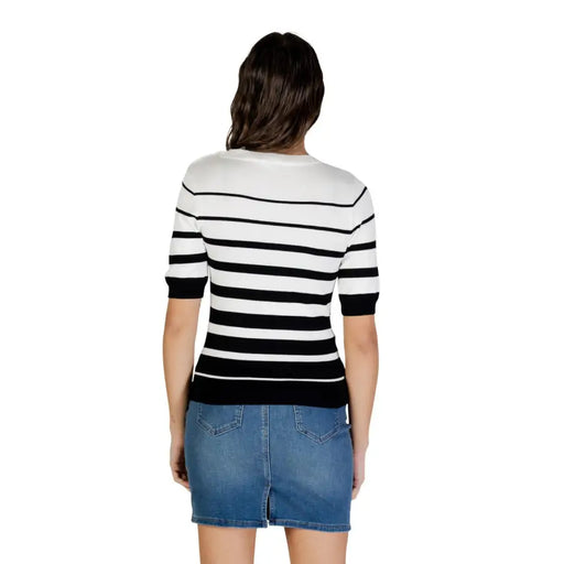 Frau in weiß gestreifter, kurzärmeliger Strickjacke mit Knöpfen, schwarz-weiße horizontale Streifen